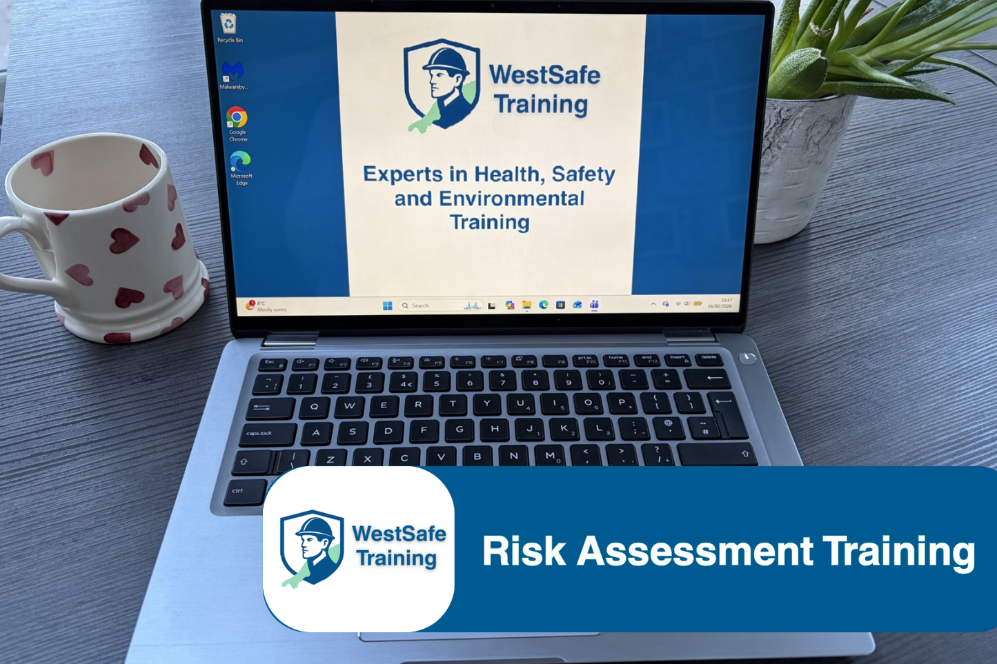 Laptop displaying WestSafe Training on a desk with a mug and plant.